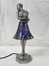 Art Deco spelter table lamp of a half nude lady in a flowing glass iridescent skirt, standing on a