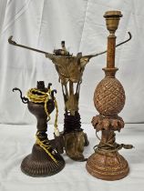 Three early 20th century table lamps, a carved pineapple form lamp, an Art Nouveau arum leaf form