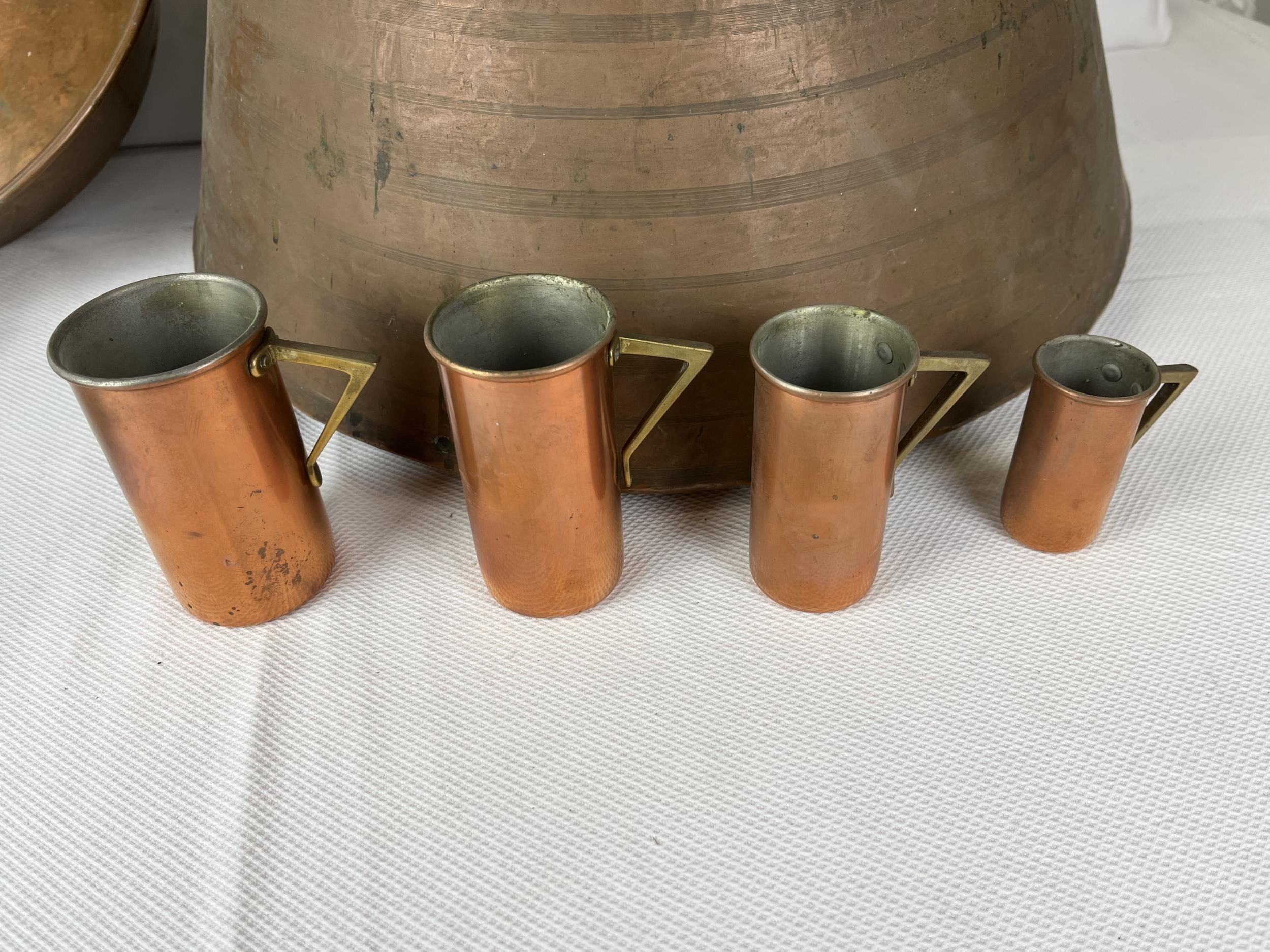 A collection of copper items; cooking vessels and measuring jugs. Largest H.20 W.45cm - Image 3 of 3