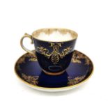 A 19th century hand painted porcelain royal blue and gilded Meissen coffee cup and saucer with