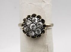 An early 20th century white metal (tests as 14 carat or higher) floral form diamond cluster ring.