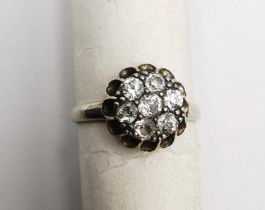 An early 20th century white metal (tests as 14 carat or higher) floral form diamond cluster ring.