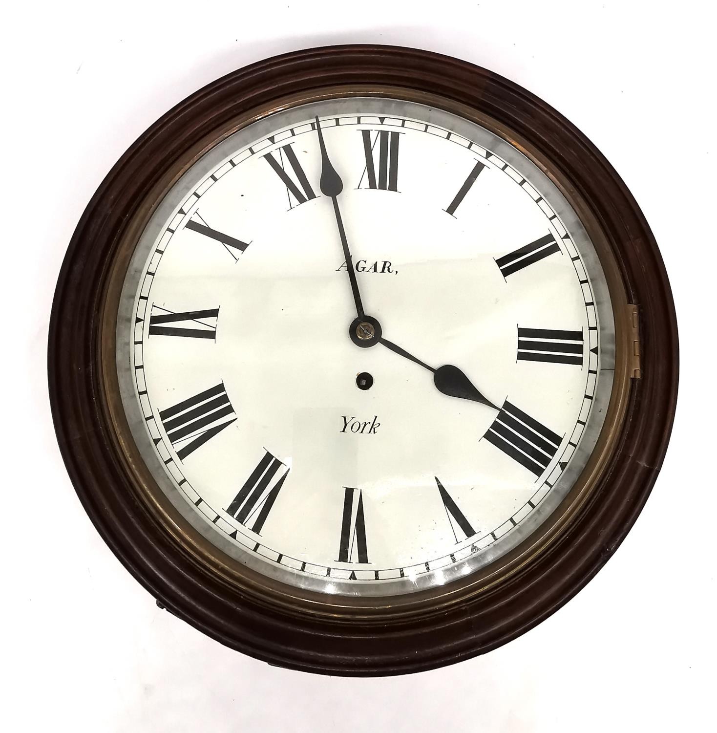 A early 20th century mahogany circular wall clock by Agar, York. Brass mechanism and white painted