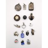 A collection of charms and silver pendants, including an Art Nouveau locket pendant, the front