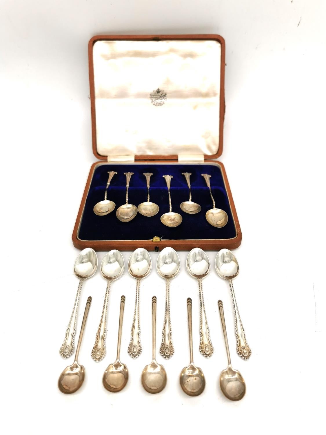 A leather cased set of six silver coffee spoons, six repousse silver teaspoons and five Art Deco