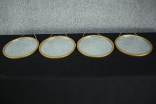 A set of four metal framed wall mirrors. Dia.33cm. (each)