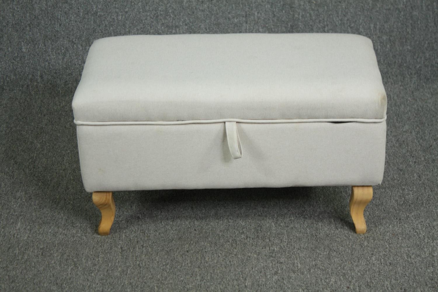 A contemporary ottoman on cabriole supports. H.40 W.70 D.37cm.
