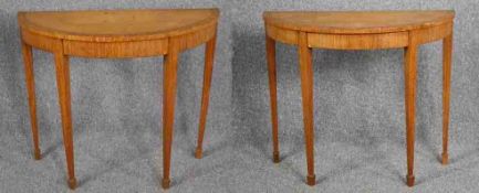 A pair of 19th century satinwood, ebony strung and crossbanded console tables raised on square