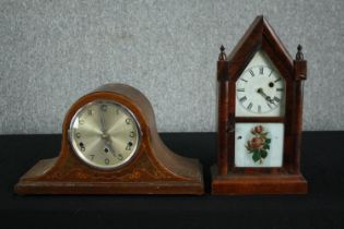 An 1870s American Gothic style clock in a steeple case with lower glass tablet decorated with roses.