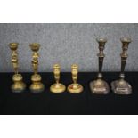 A pair of gilt bronze candlesticks of urn form, a pair of brass Egyptian revival similar along