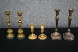 A pair of gilt bronze candlesticks of urn form, a pair of brass Egyptian revival similar along