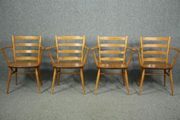Dining chairs, a set of four with arms, Ercol model 559A in beech and elm.