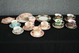 A collection of tea cups and saucers, including an orange and white early 20th century floral design