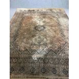 A Persian carpet with central medallions and stylised floral motifs across the field within