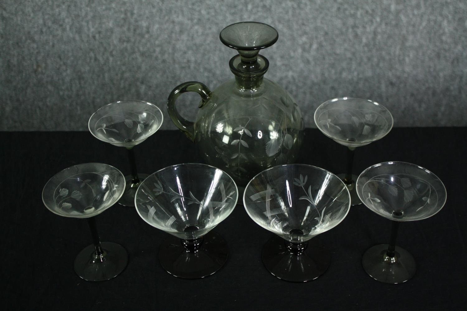 A Swedish smokey etched glass spherical decanter with conical stopper and four matching glasses
