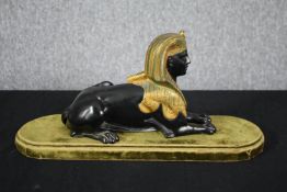 A Grand Tour Egyptian Revival spelter and gilt figure of a recumbent Sphinx. H.20 W.43 D.14cm.