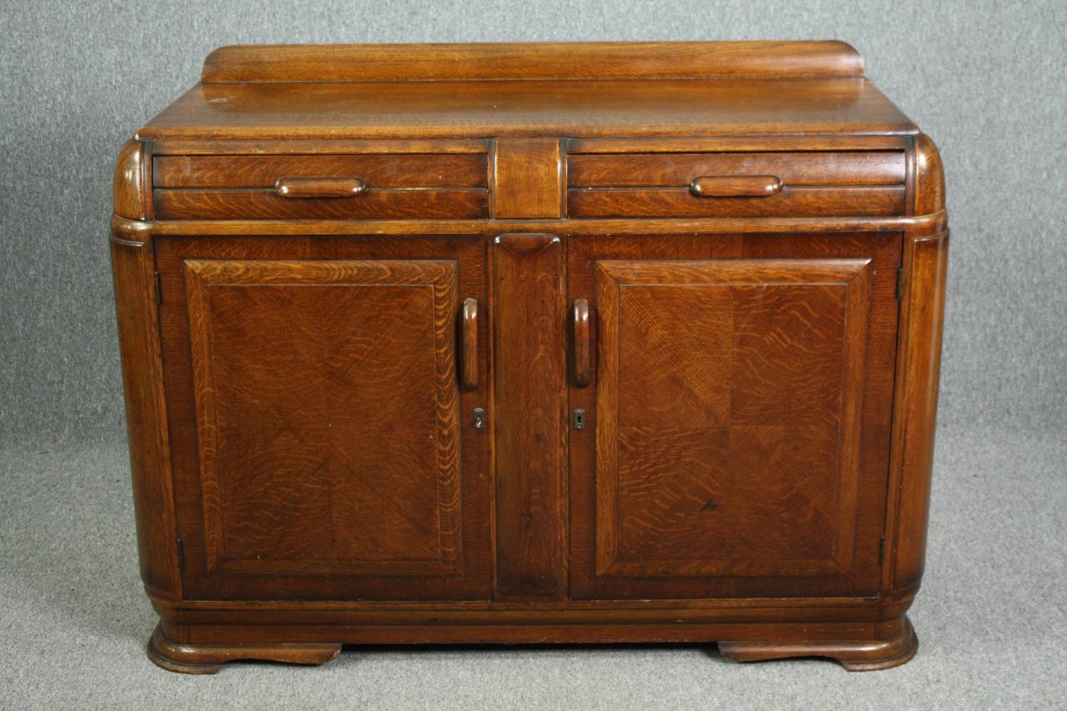 A mid century Art Deco style oak dwarf sideboard. H.103 W.137 D.52cm.