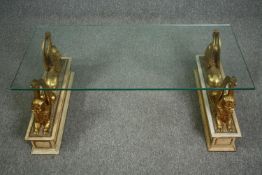 Coffee table, with plate glass top supported by twin gilt winged sphinxes on painted pedestals. H.42