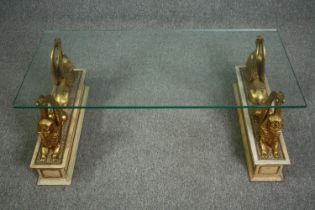 Coffee table, with plate glass top supported by twin gilt winged sphinxes on painted pedestals. H.42