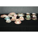 A collection of tea cups and saucers, including an orange and white early 20th century floral design