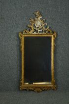 Wall mirror, late 19th century carved giltwood with Rococo scroll cresting. H.132 W.61cm.