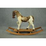 A vintage rocking horse in cowhide covering. H.74 W.110 D.38cm.