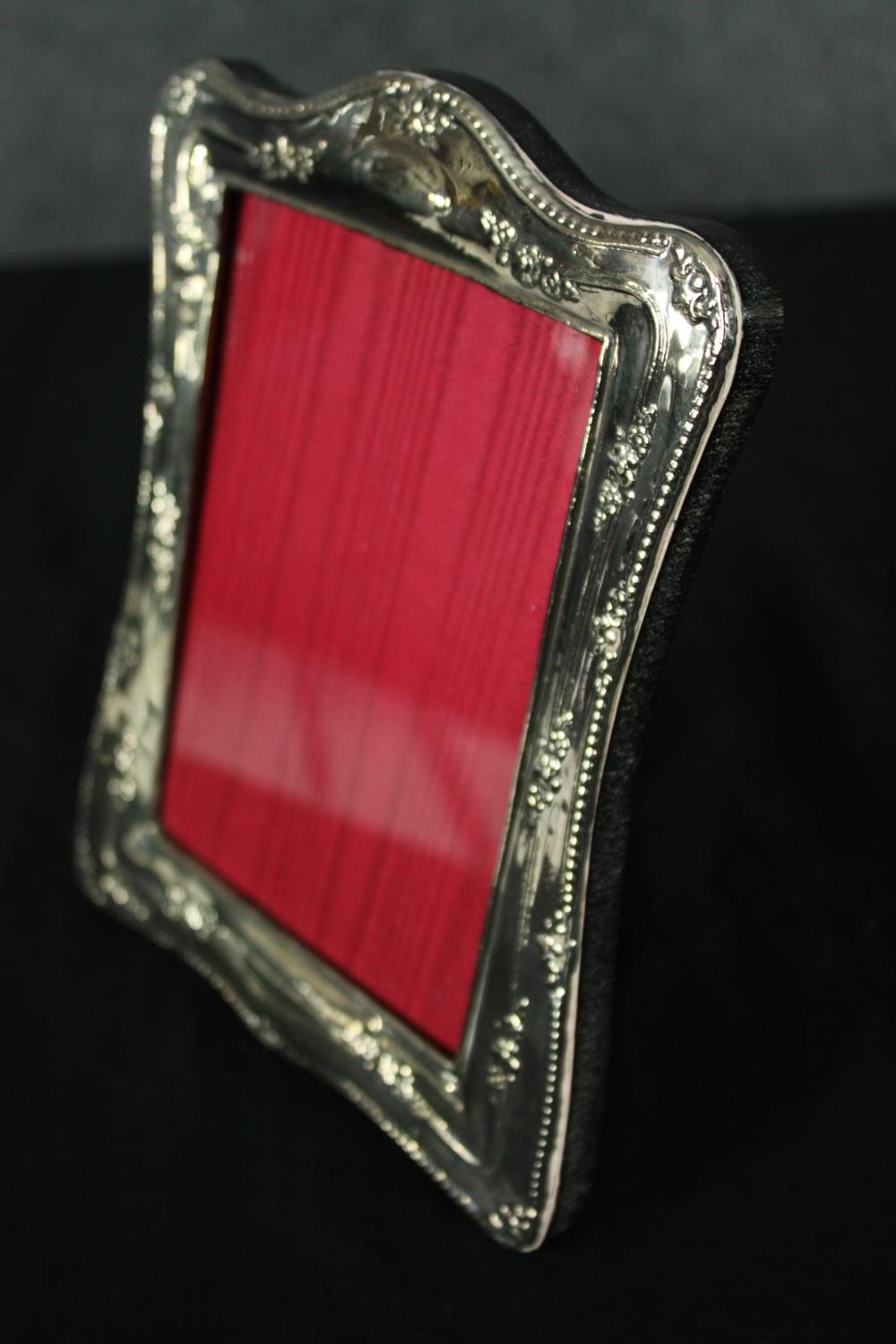 A repousse silver photograph frame bearing English hallmarks. H.19 W.14cm. - Image 3 of 5
