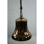 A modern decorative ceramic bell finished in a brass lustre. With a ceiling mount suspended by a