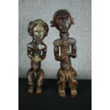 An African carved hardwood ancestor figure, possibly 19th century along with a similar example. H.