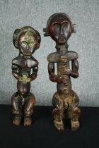 An African carved hardwood ancestor figure, possibly 19th century along with a similar example. H.