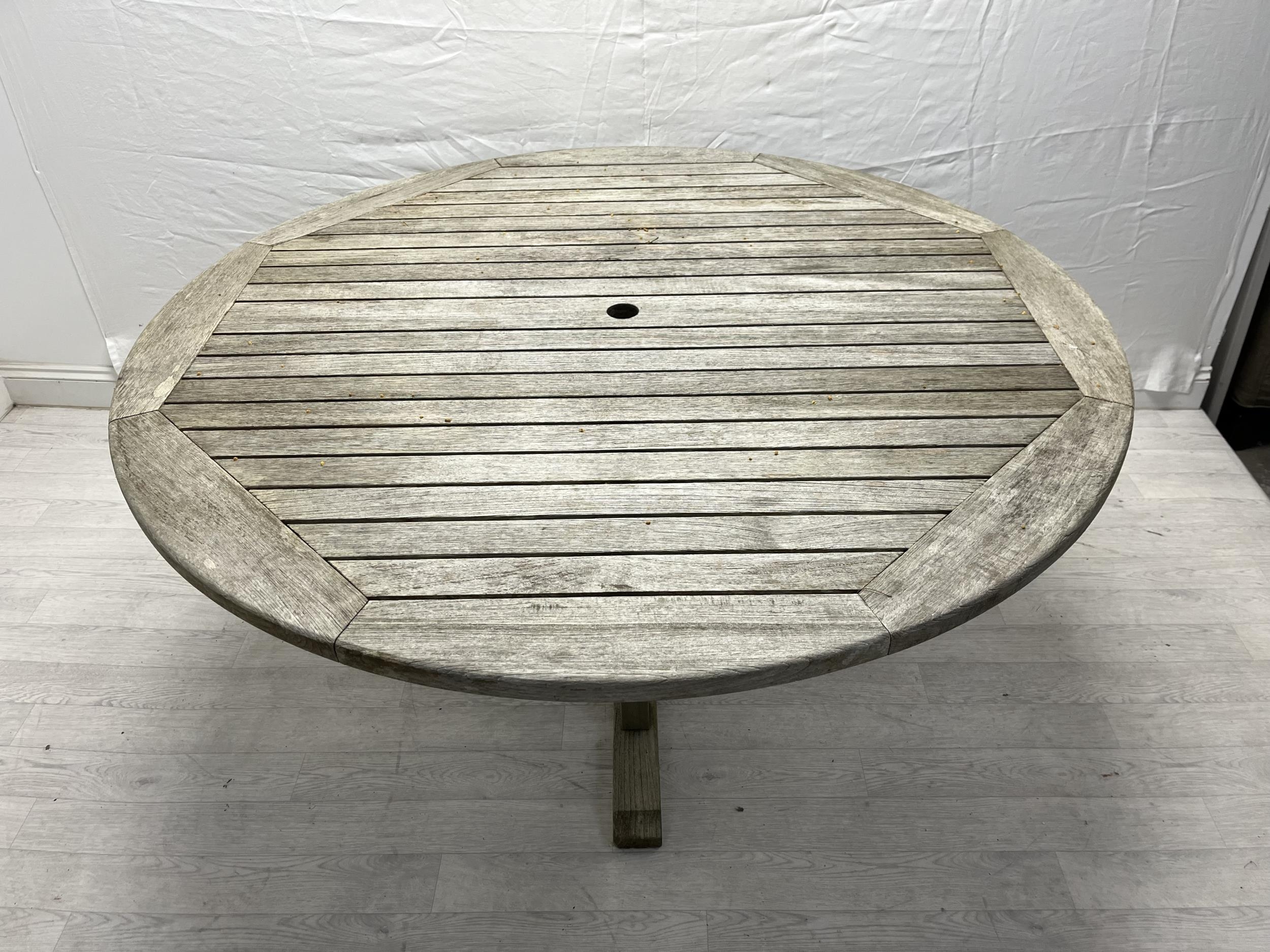 A vintage weathered teak garden table. H.72cm Dia.150cm. - Image 2 of 4