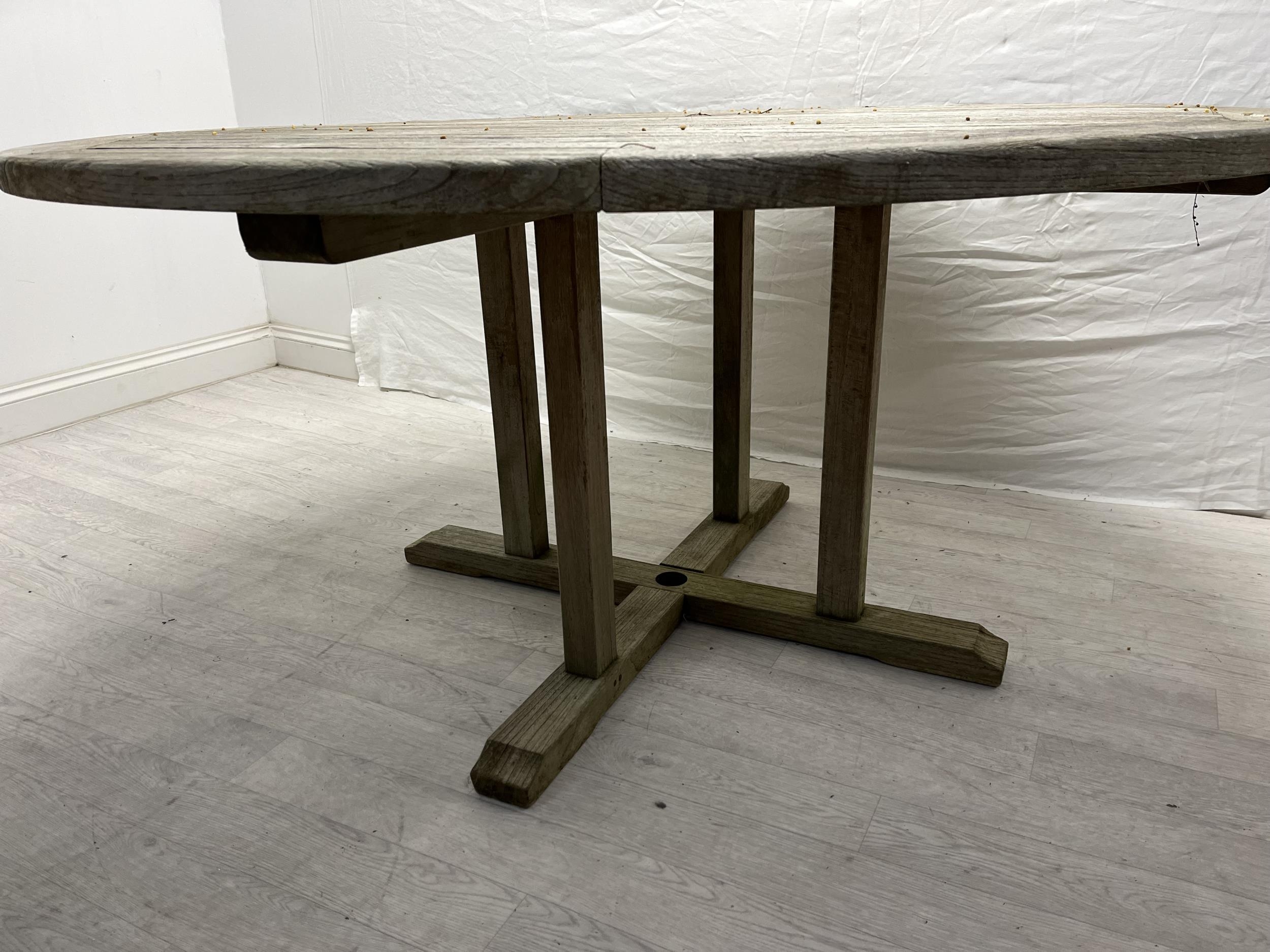 A vintage weathered teak garden table. H.72cm Dia.150cm. - Image 3 of 4