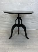 An industrial style metal table with hand wound rise and fall mechanism. H.74 Dia.77cm.