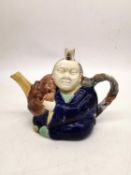 A 19th century Minton Majolica teapot of an oriental china man in cobalt robe, holding a Noh mask