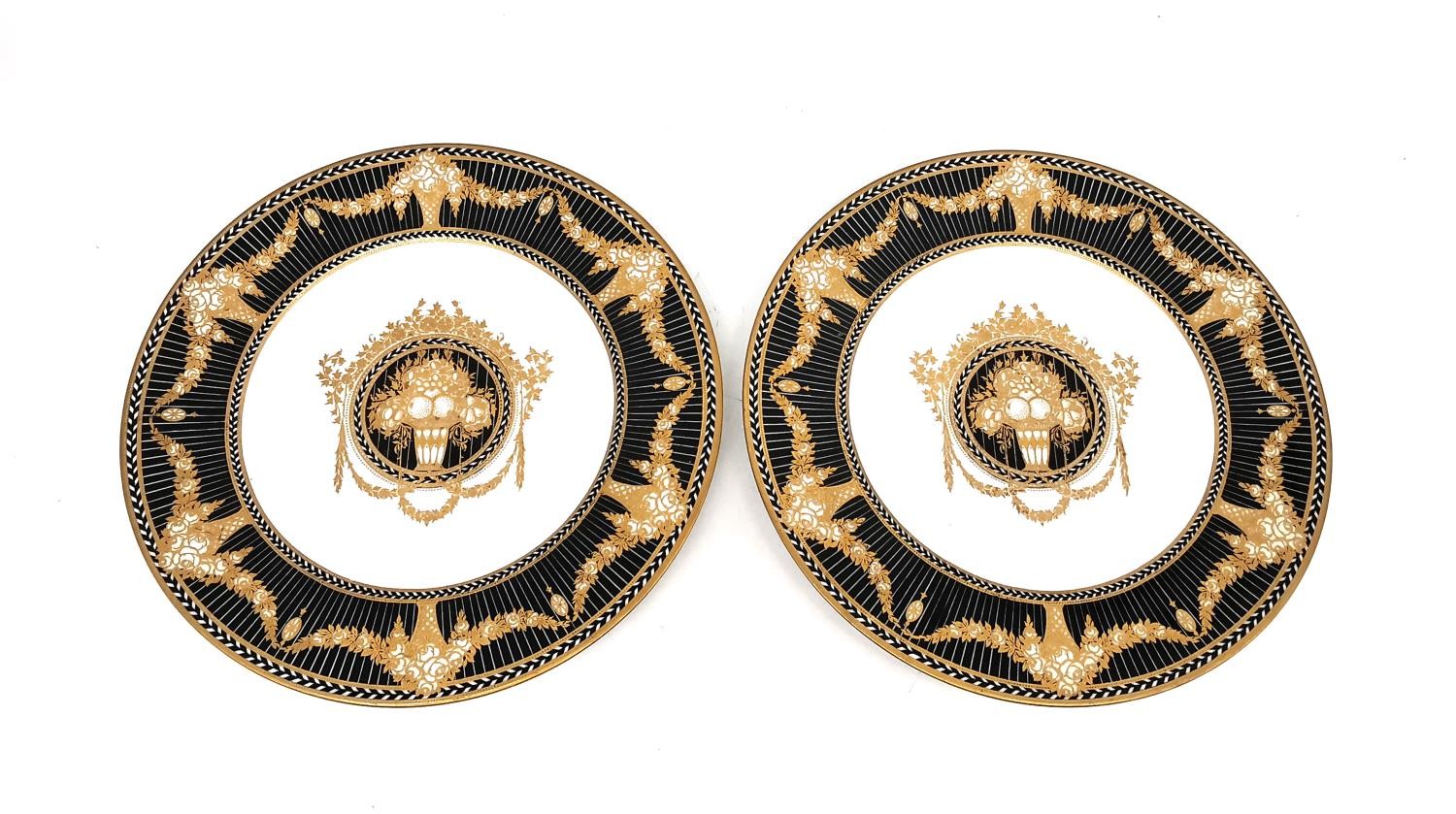 A pair of early 20th century Royal Worcester black transfer printed and hand gilded cabinet plates