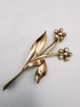 A early 20th century 14 carat rose gold and diamond brooch floral spray brooch. Set with ten round