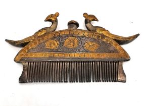 A 19th century Indian white metal and gilt moustache and beard comb of crescent form with a cast