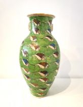 A large twin handled Persian Iznik ceramic vase with green ground and painted fish. H.54 D.25cm.