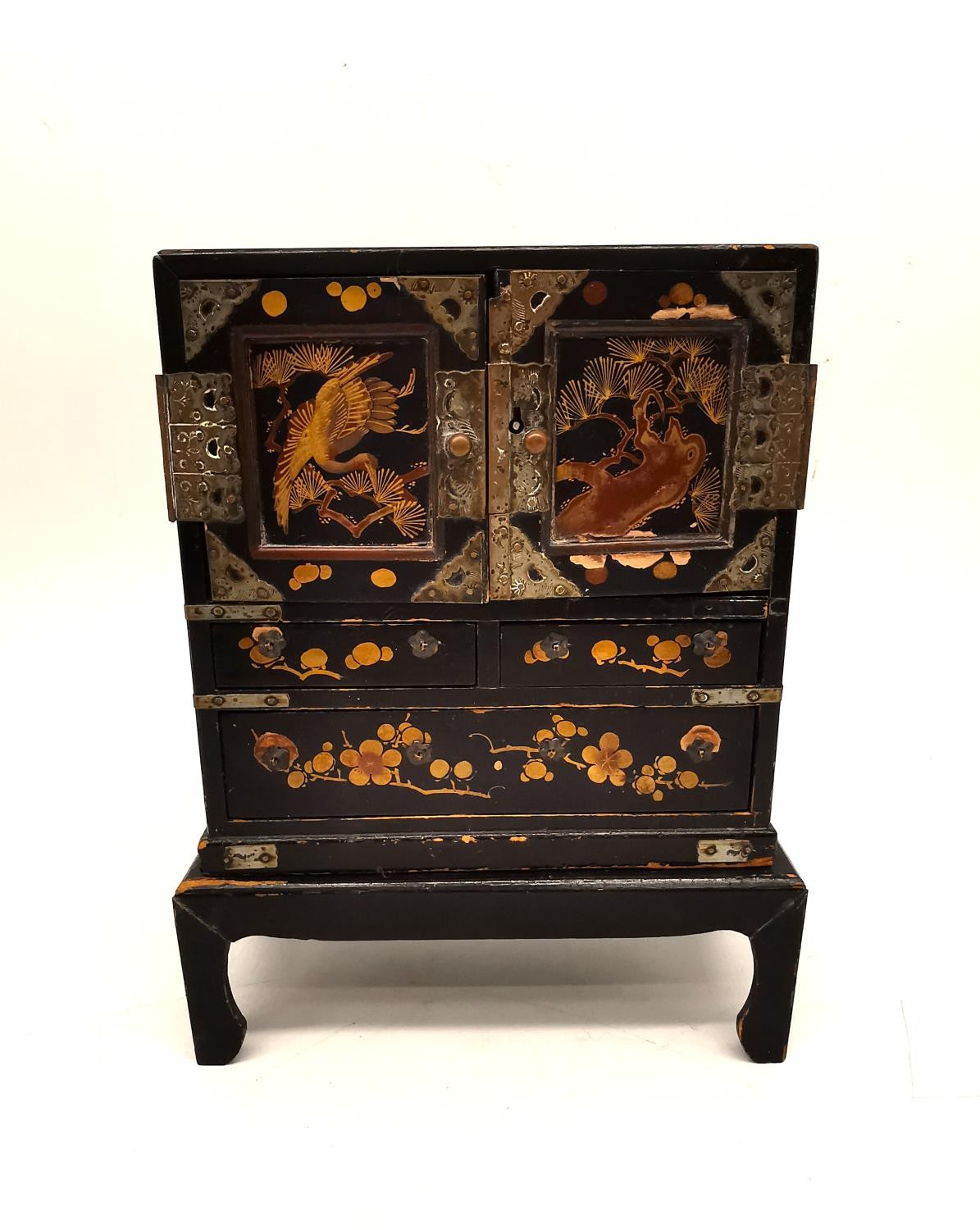 A late 19th century Japanese lacquered and gilded jewellery cabinet on stand. Each door decorated