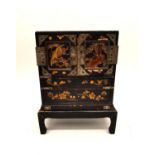 A late 19th century Japanese lacquered and gilded jewellery cabinet on stand. Each door decorated