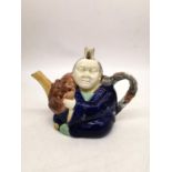 A 19th century Minton Majolica teapot of an oriental china man in cobalt robe, holding a Noh mask