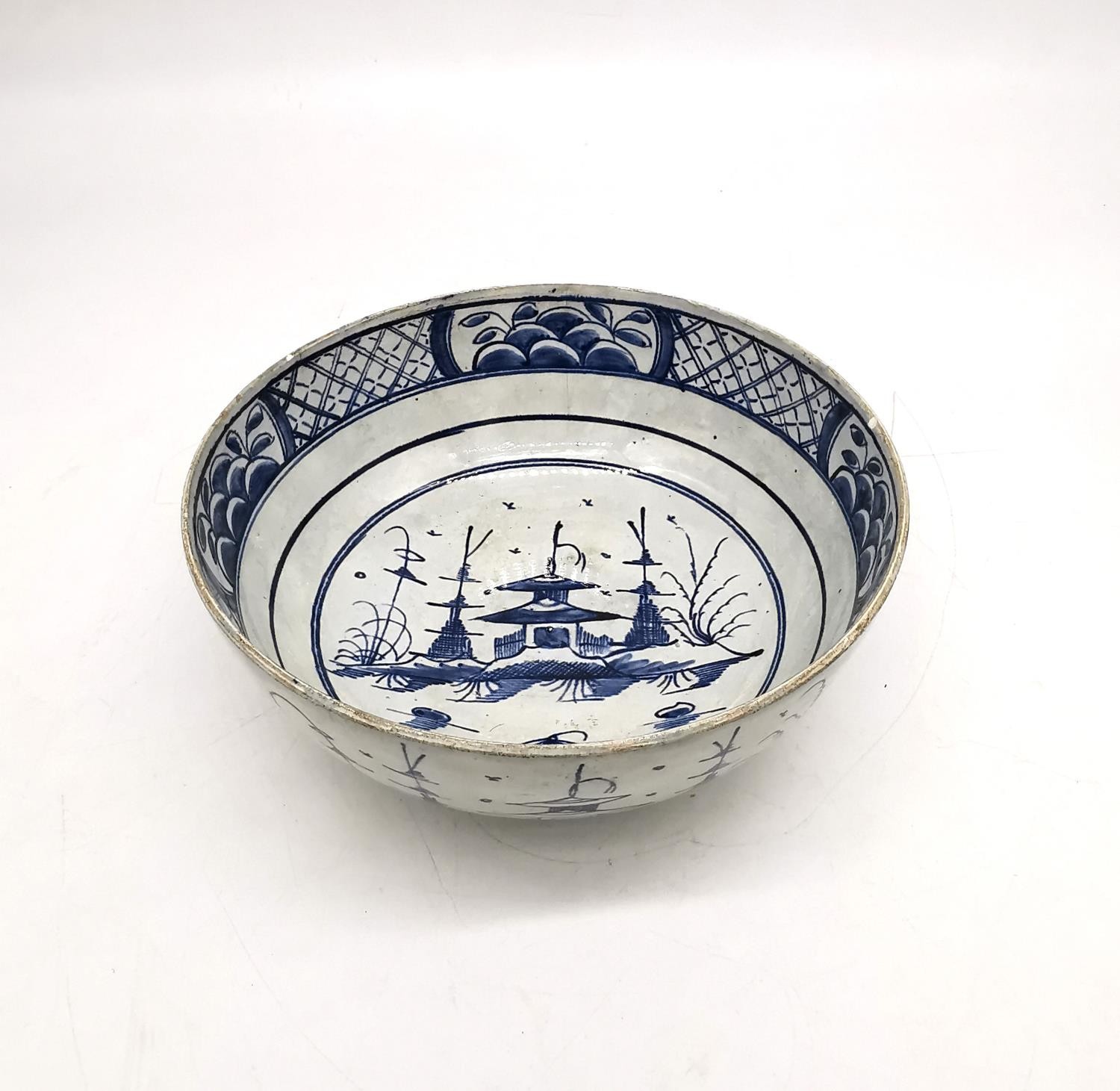 A 18th century Delft blue and white Chinese design bowl with pagoda and tree design. (chipped and