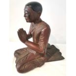 A 19th/early 20th century carved and lacquered Burmese kneeling figure of a praying monk wearing a