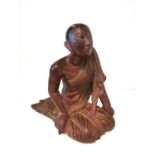 A 19th/early 20th century carved and lacquered Burmese kneeling figure of a monk wearing a robe. The