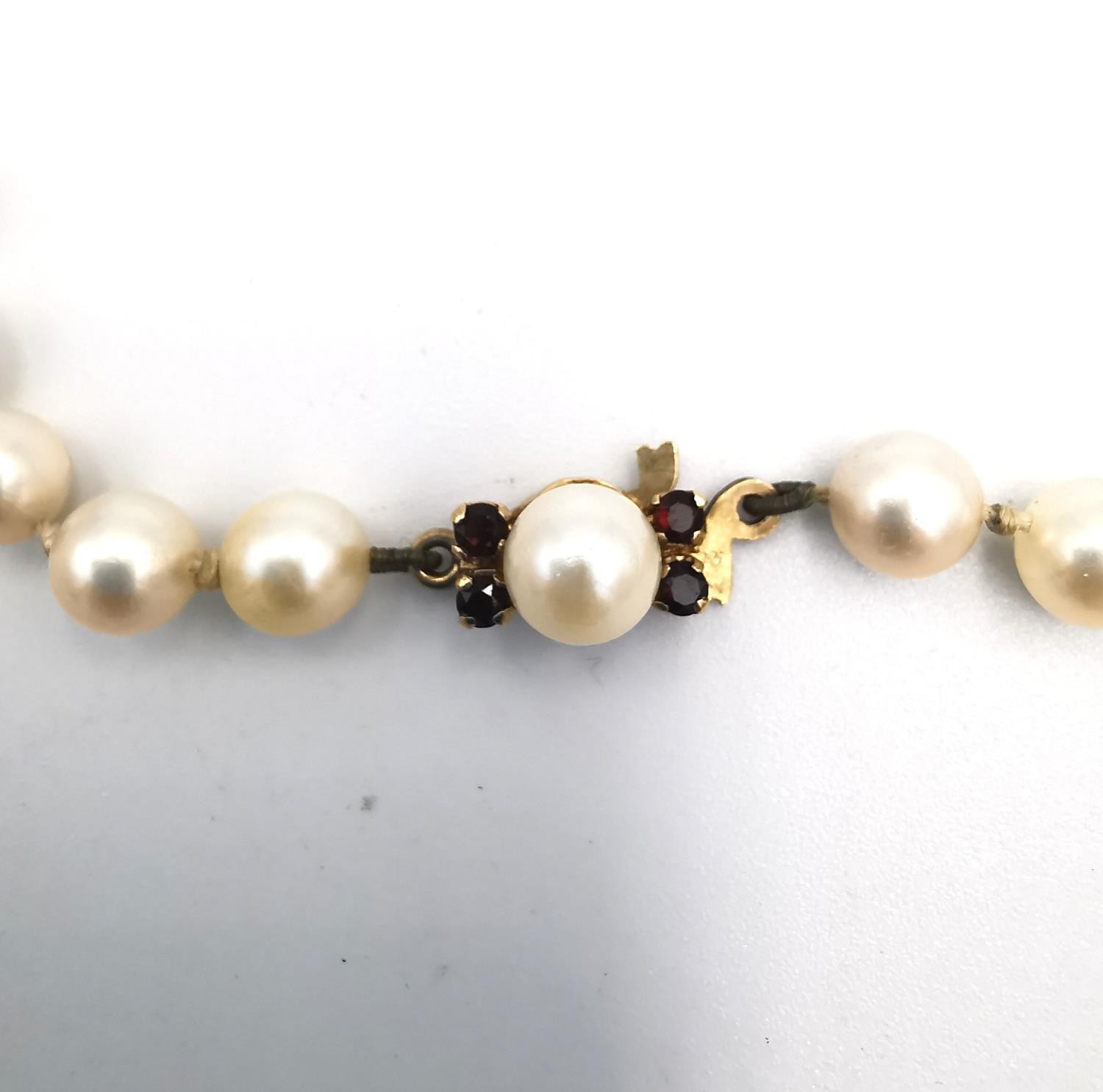 A long knotted string of graduated cultured pearls with 9ct yellow gold red stone set hook and - Image 5 of 8