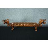 A hardwood decorative Mancala board game in the shape of a dragon. With carved decoration and