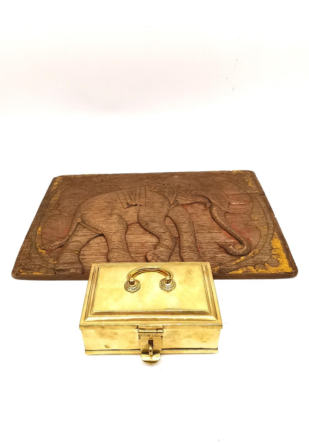 A 19th Century Indian brass lockable spice box and craved hardwood elephant design panel. L.16 D.