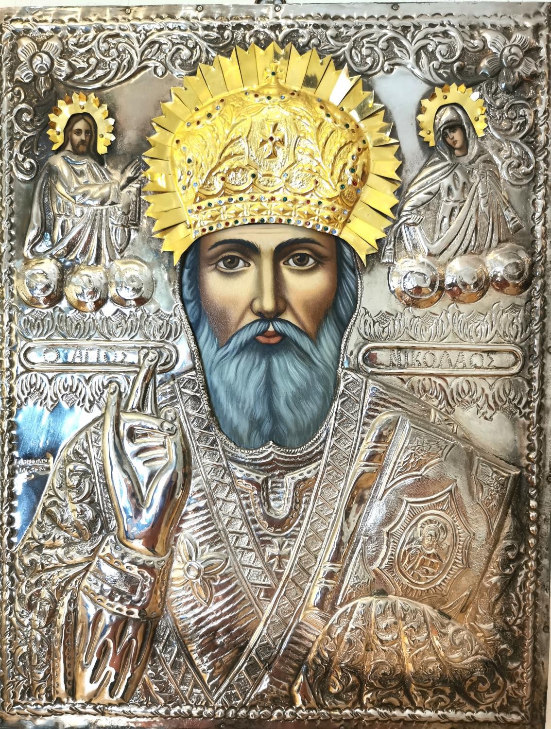 A large Mid-century silver Greek Orthodox icon on board of Saint Frances. Hand painted faces and