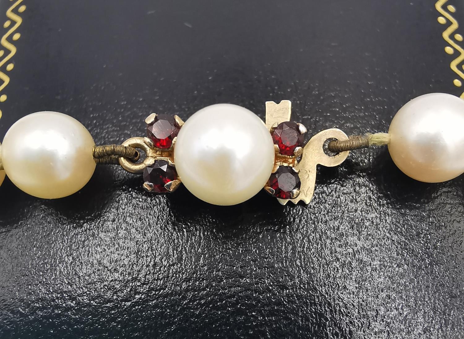 A long knotted string of graduated cultured pearls with 9ct yellow gold red stone set hook and - Image 7 of 8