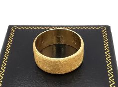 An 18ct yellow gold wide textured band. Inscribed to the interior Robin and a date. Stamped 18K,750.